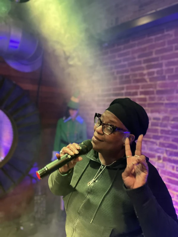 Singer on stage of Speakeasy surrounded by smoke and lights