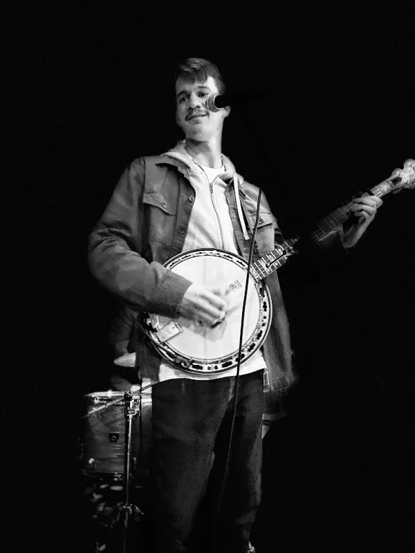 Black and white photo of person playing Banjo at Speakeasy