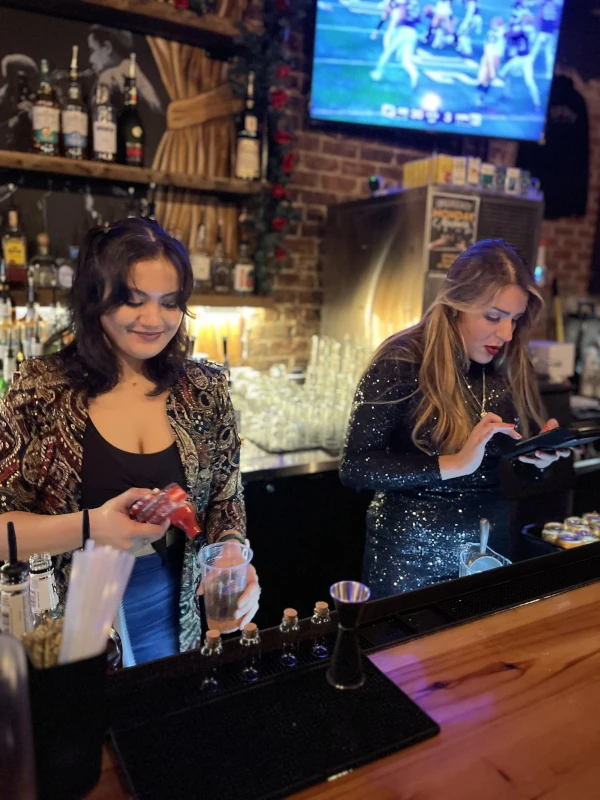 Two bartenders at Speakeasy preparing drinks for customers