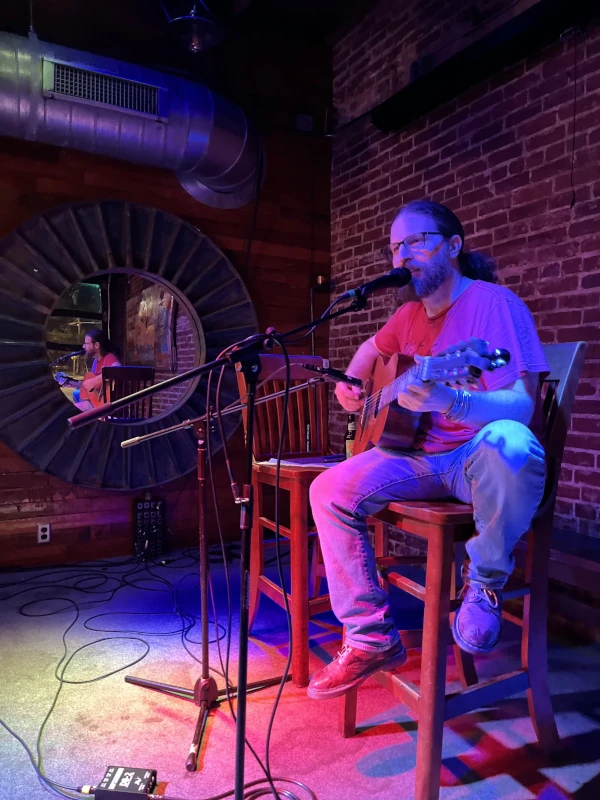 Man playing guitar and singing on stage